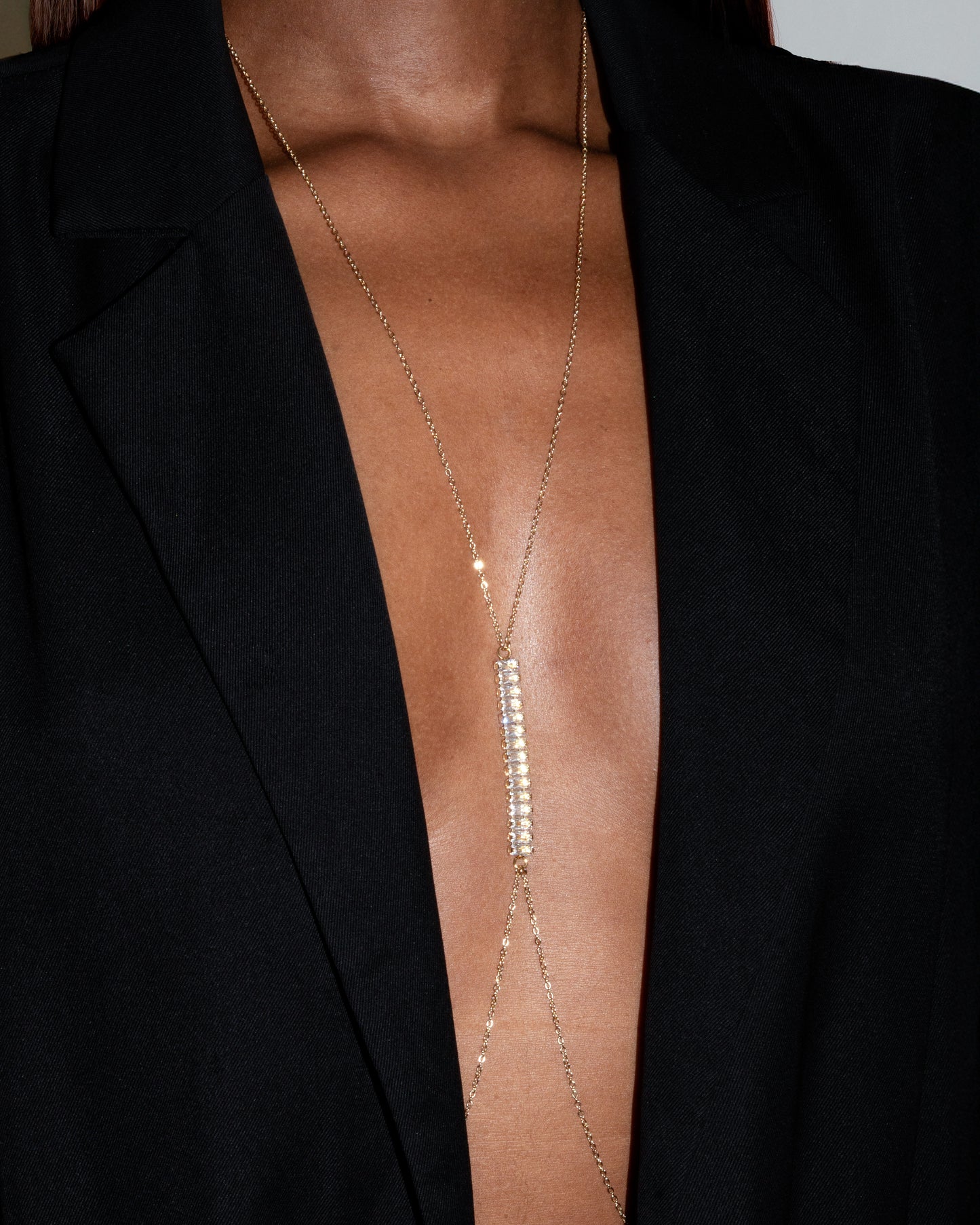 Axis necklace by Studio Baloge — gold-filled chain with vertical pavé crystal bar worn with deep V neckline.