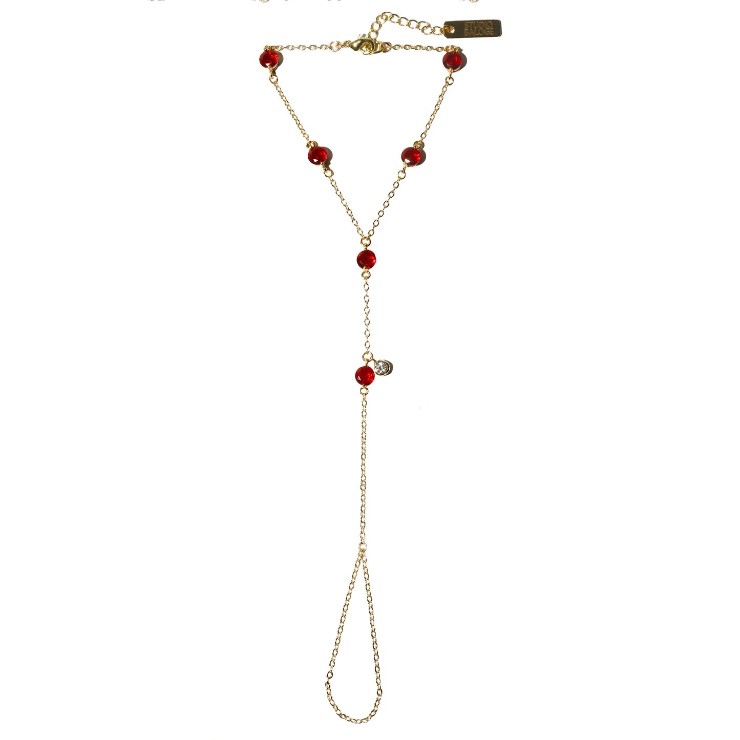 Gold hand harness with red gemstones on a white background