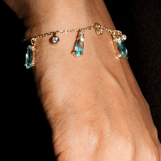 Hand wearing a bracelet with gemstones on a black background