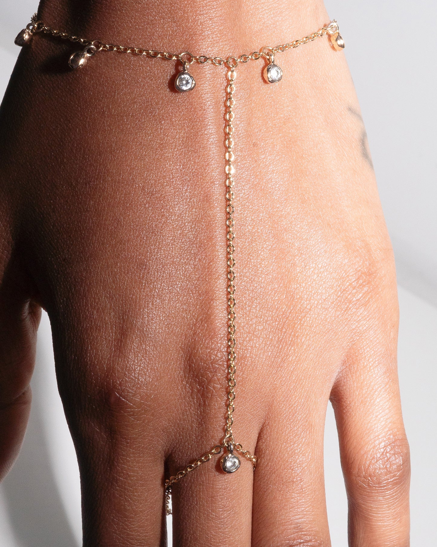 Close-up of gold filled Delilah Hand Harness by Studio Baloge, featuring delicate crystal bezel drops and fine chainwork. Minimalist statement jewelry for modern feminine style.