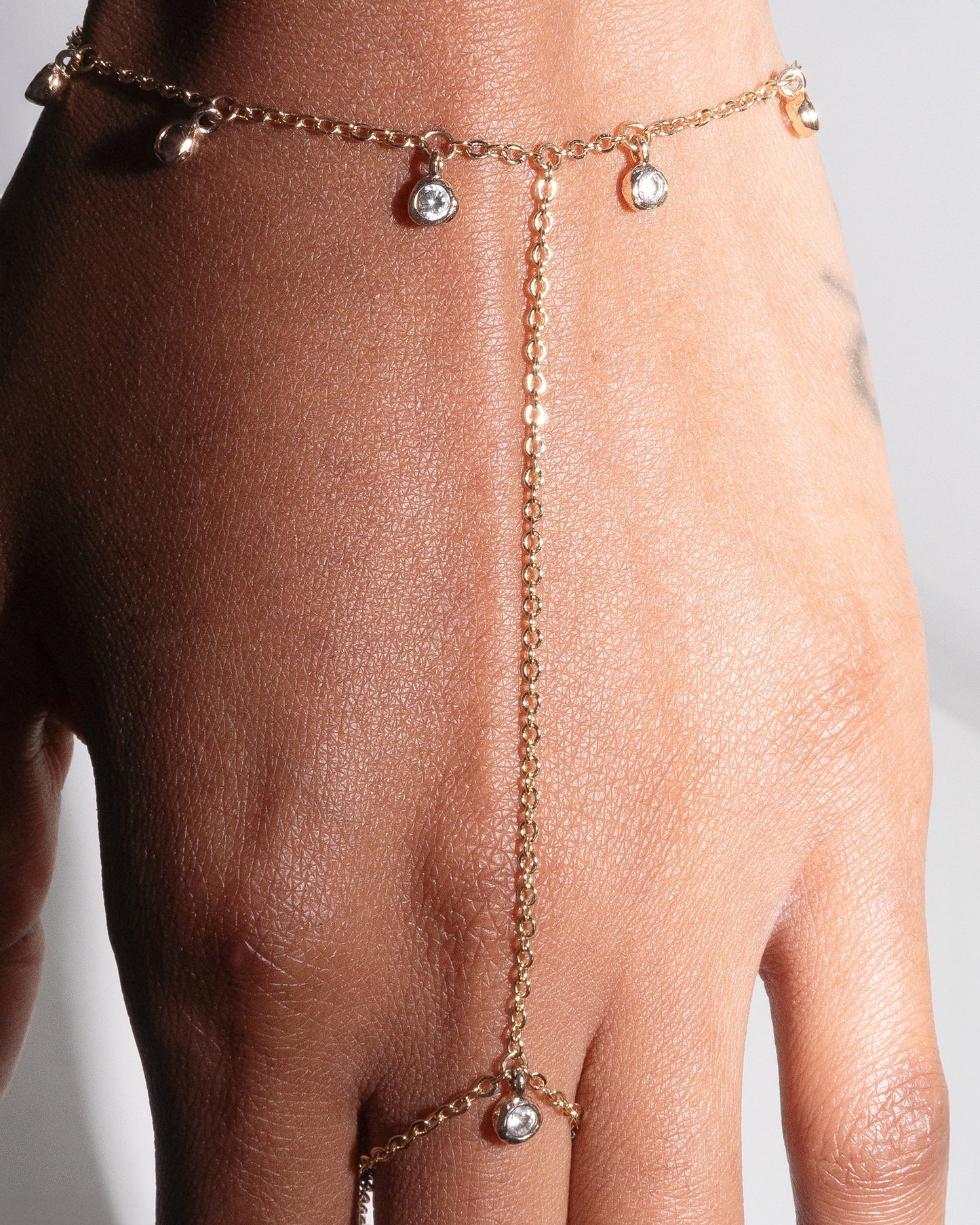Close-up of gold filled Delilah Hand Harness by Studio Baloge, featuring delicate crystal bezel drops and fine chainwork. Minimalist statement jewelry for modern feminine style.