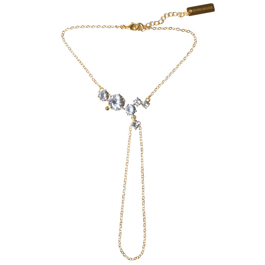Gold hand chain with gemstones on a white background