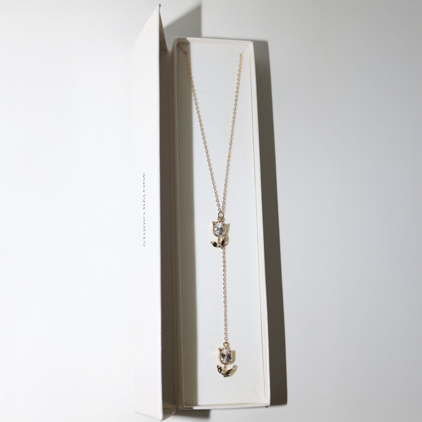 Gold lariat necklace with two tulip pendants in Studio Baloge Box