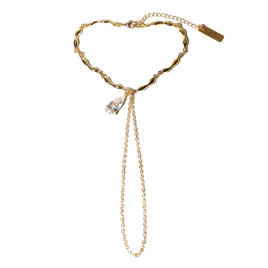 Gold bracelet with a heart-shaped clasp and chain on a white background