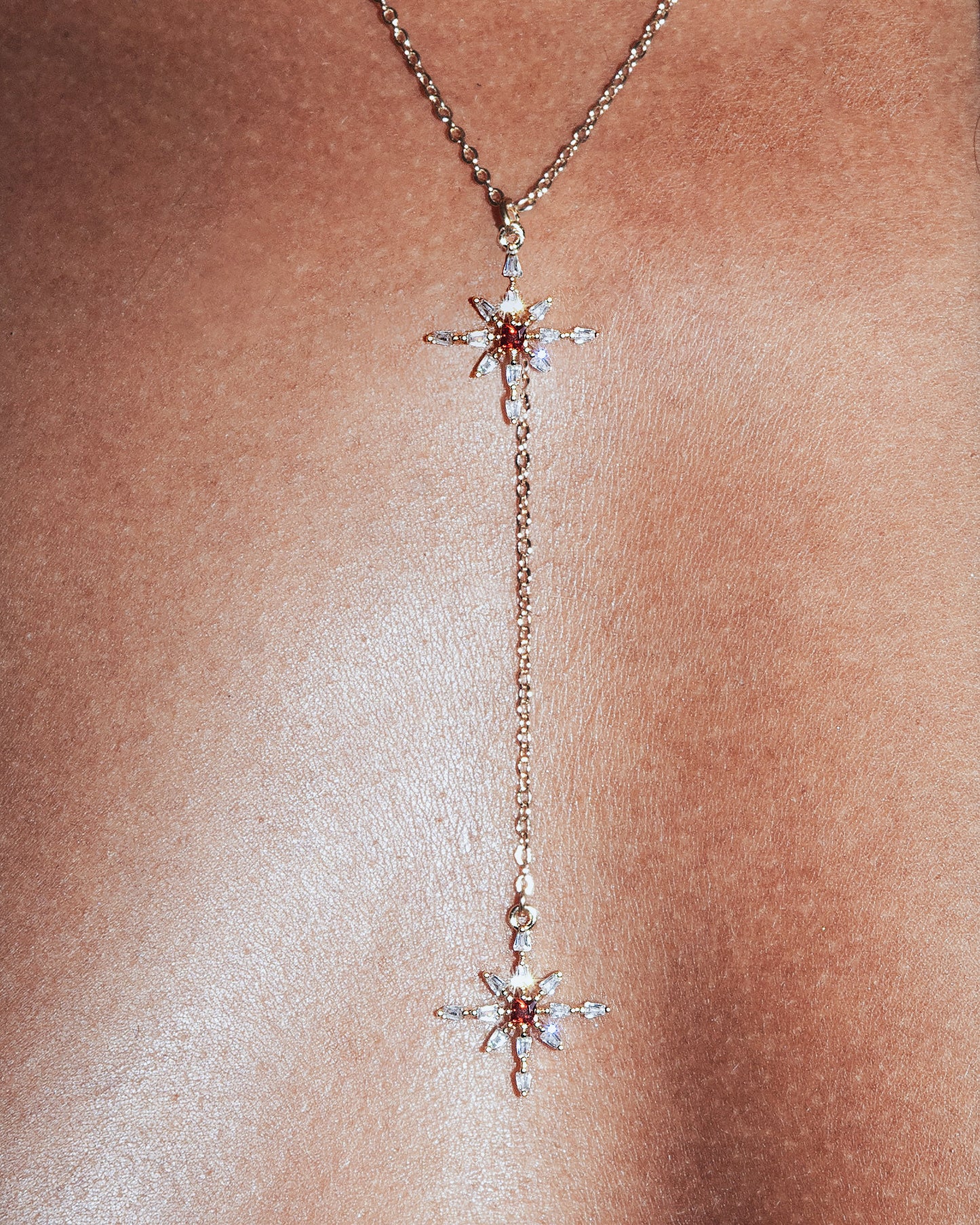 Delicate gold necklace with star-shaped pendants on a person's neck