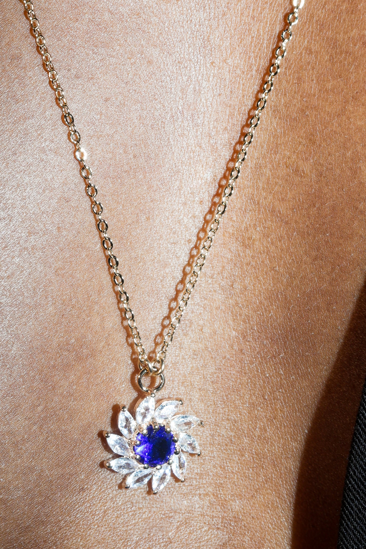 Necklace with a blue gemstone pendant on a person's neck
