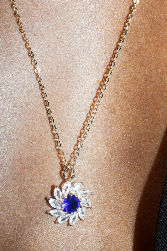 Necklace with a blue gemstone pendant on a person's neck