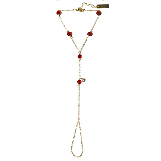 Gold hand harness with red gemstones on a white background