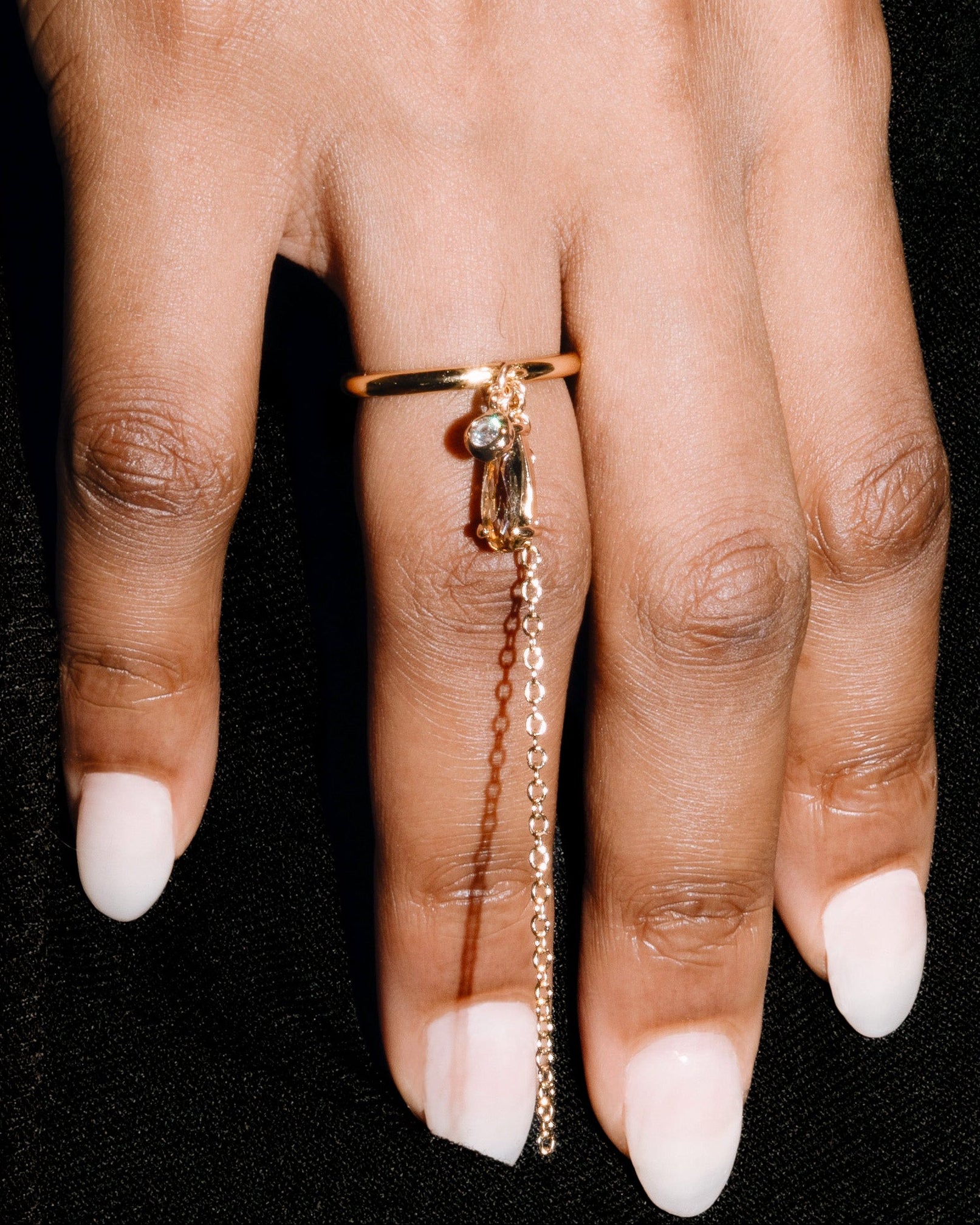 Hand wearing a ring on a black background