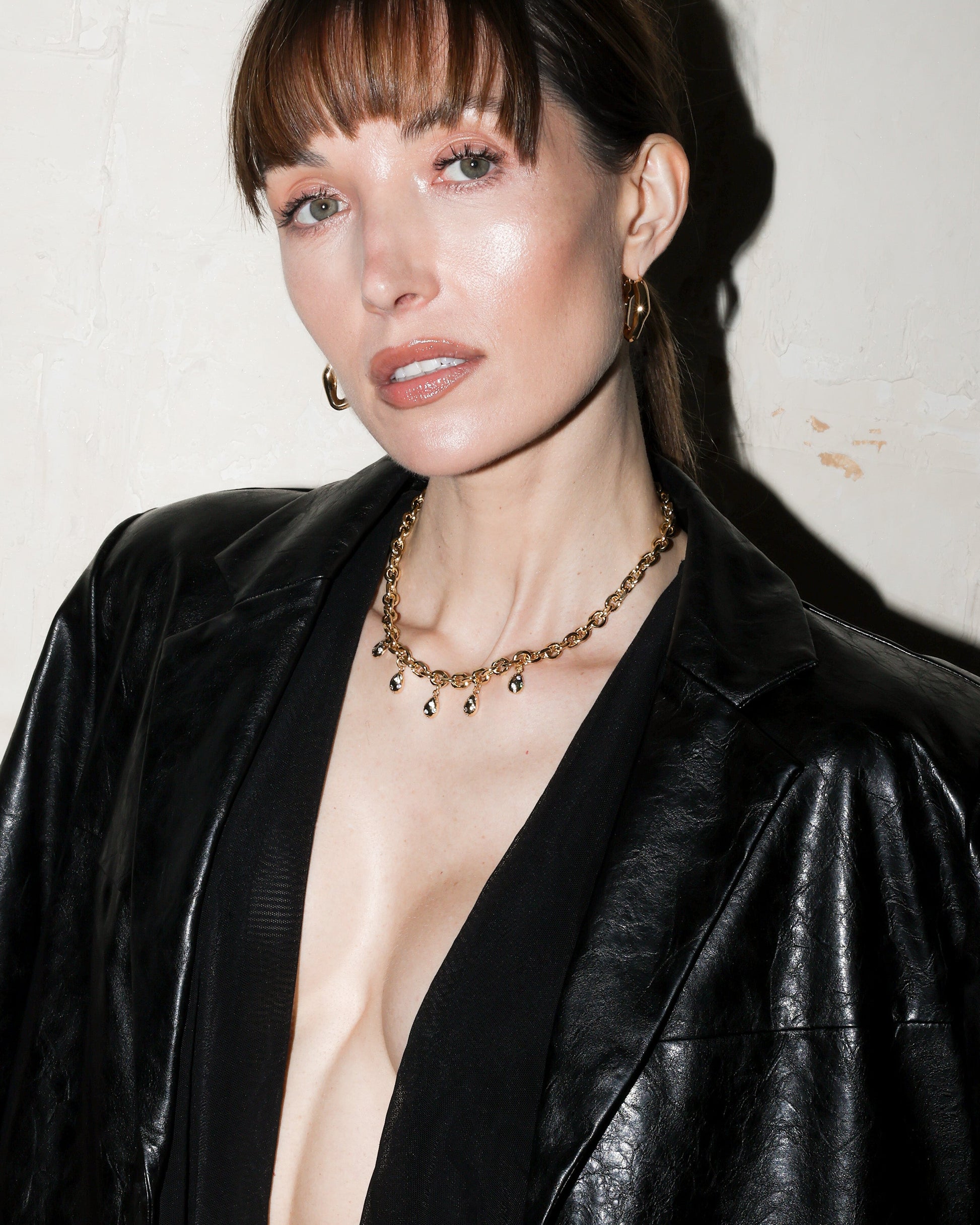 Woman wearing a black leather jacket with a white background