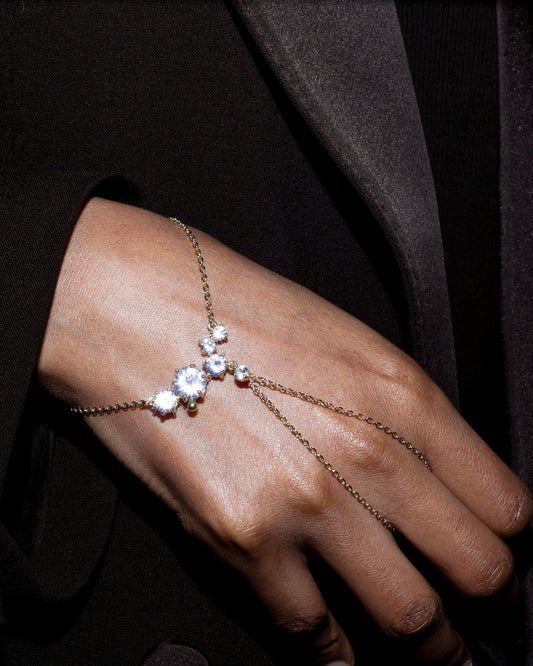 Delicate diamond bracelet on a person's wrist against a dark background