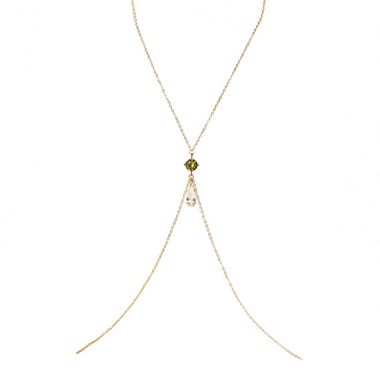 Delicate gold body chain with a green gemstone on a white background