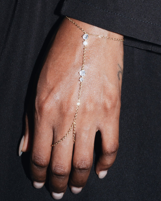 Delicate gold hand harness bracelet—Studio Baloge ‘Nalya’ design shown on model hand with clear crystal accents.
