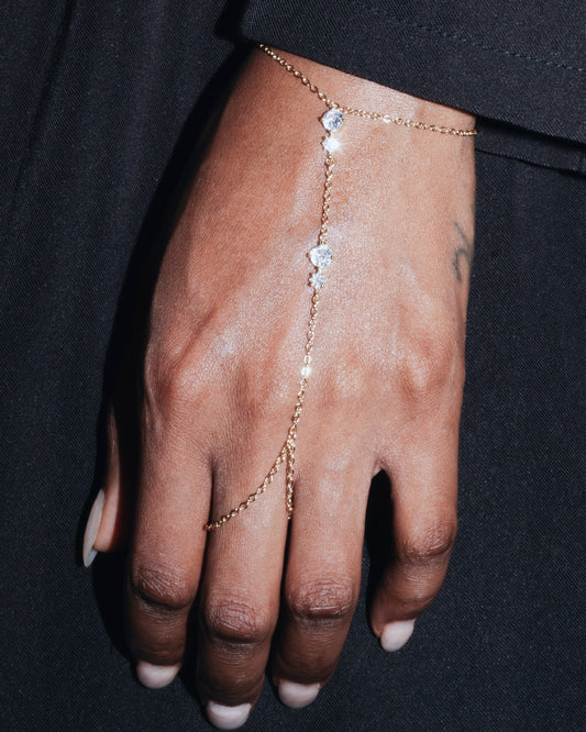 Delicate gold hand harness bracelet—Studio Baloge ‘Nalya’ design shown on model hand with clear crystal accents.