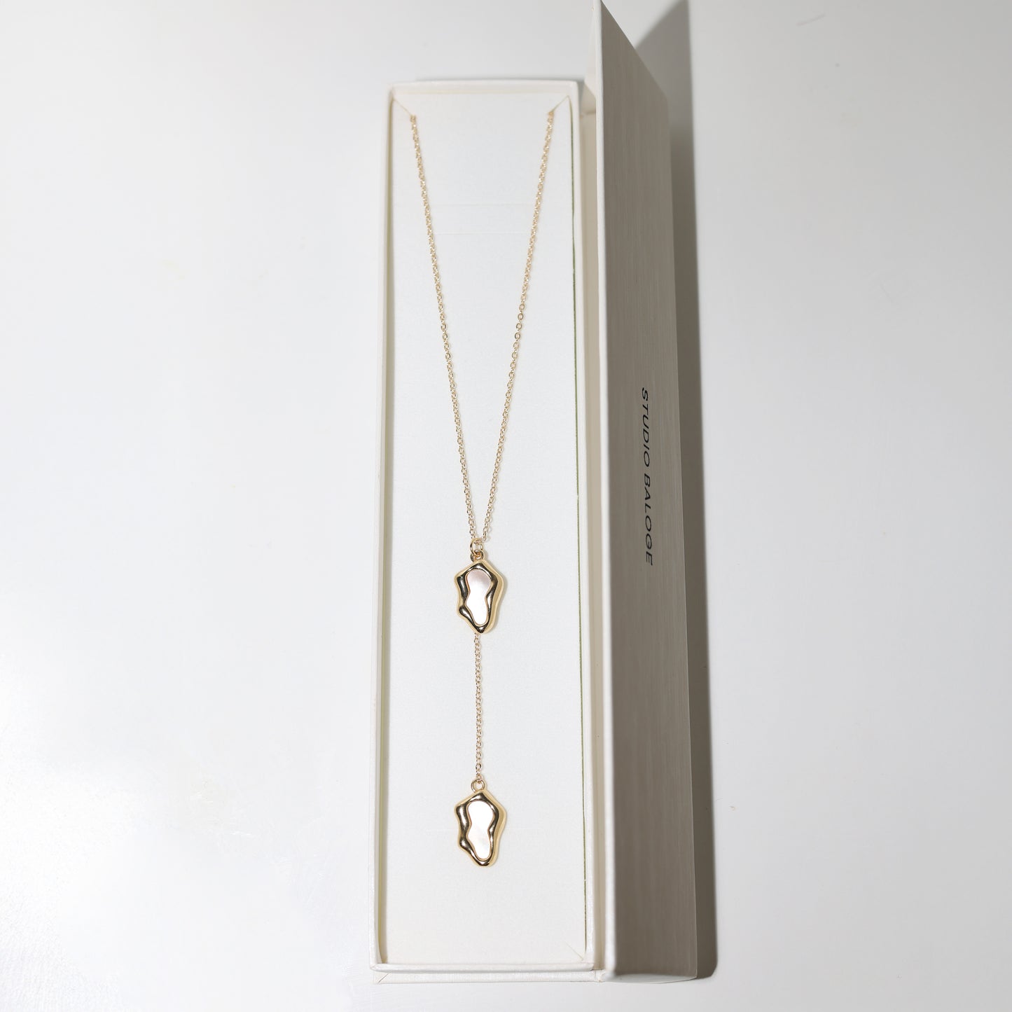 Studio Balogé Oceane Lariat Necklace featuring an 18-inch gold-filled chain with sculptural shell-pearl charms and a delicate vertical drop in Box