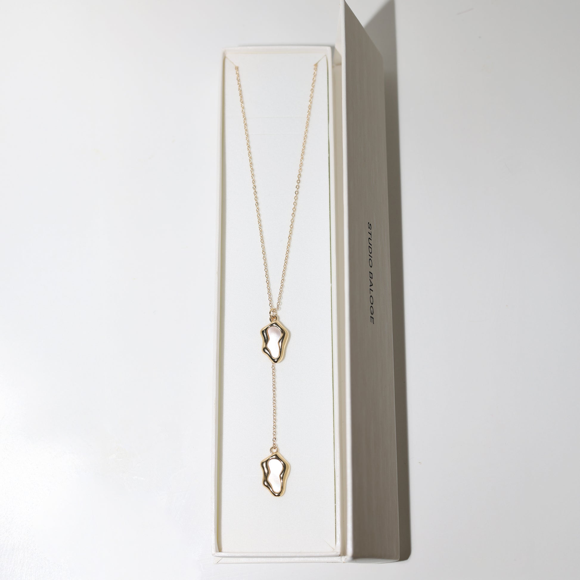 Studio Balogé Oceane Lariat Necklace featuring an 18-inch gold-filled chain with sculptural shell-pearl charms and a delicate vertical drop in Box