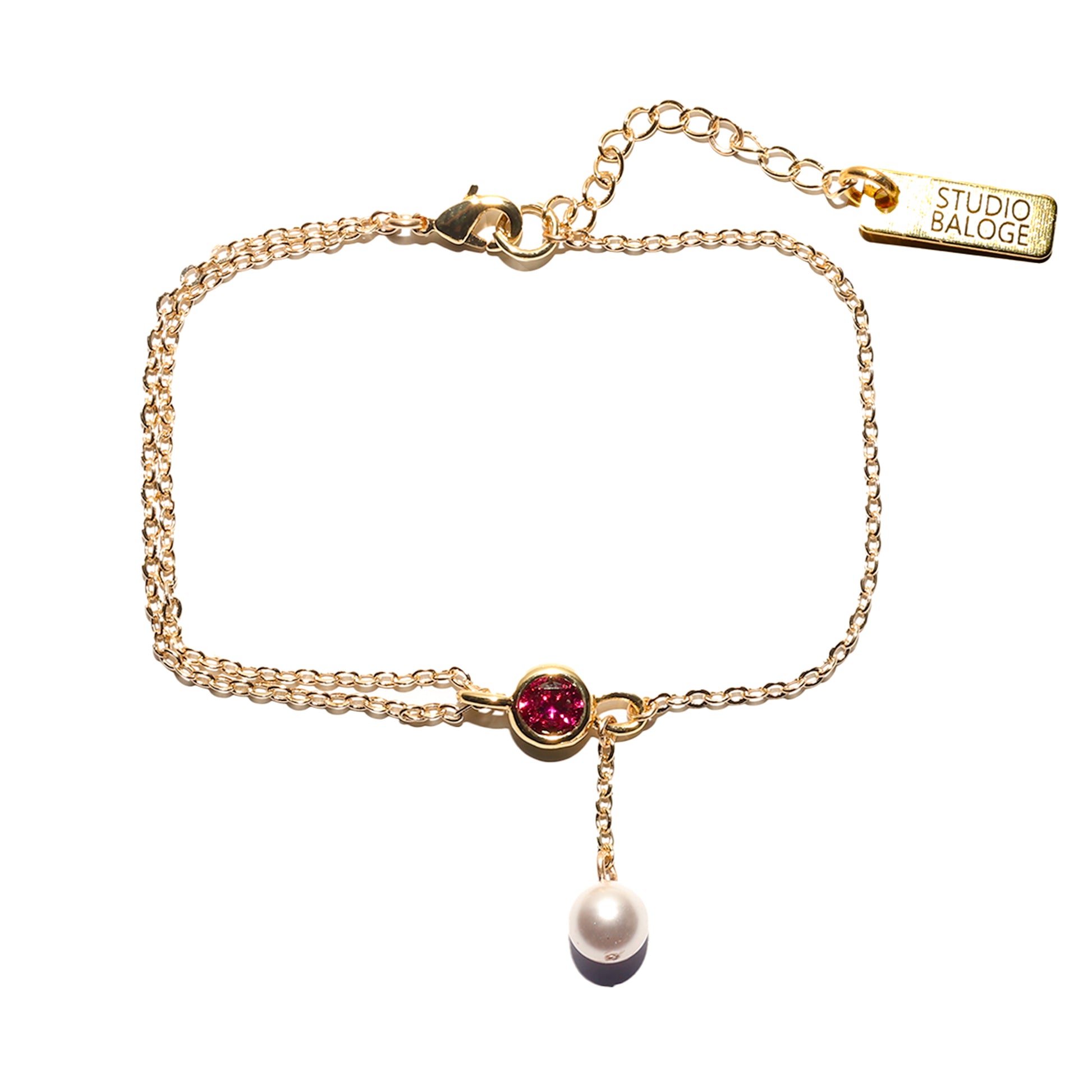 Gold bracelet with a pink gemstone and pearl on a white background, featuring the Studio Baloge brand.