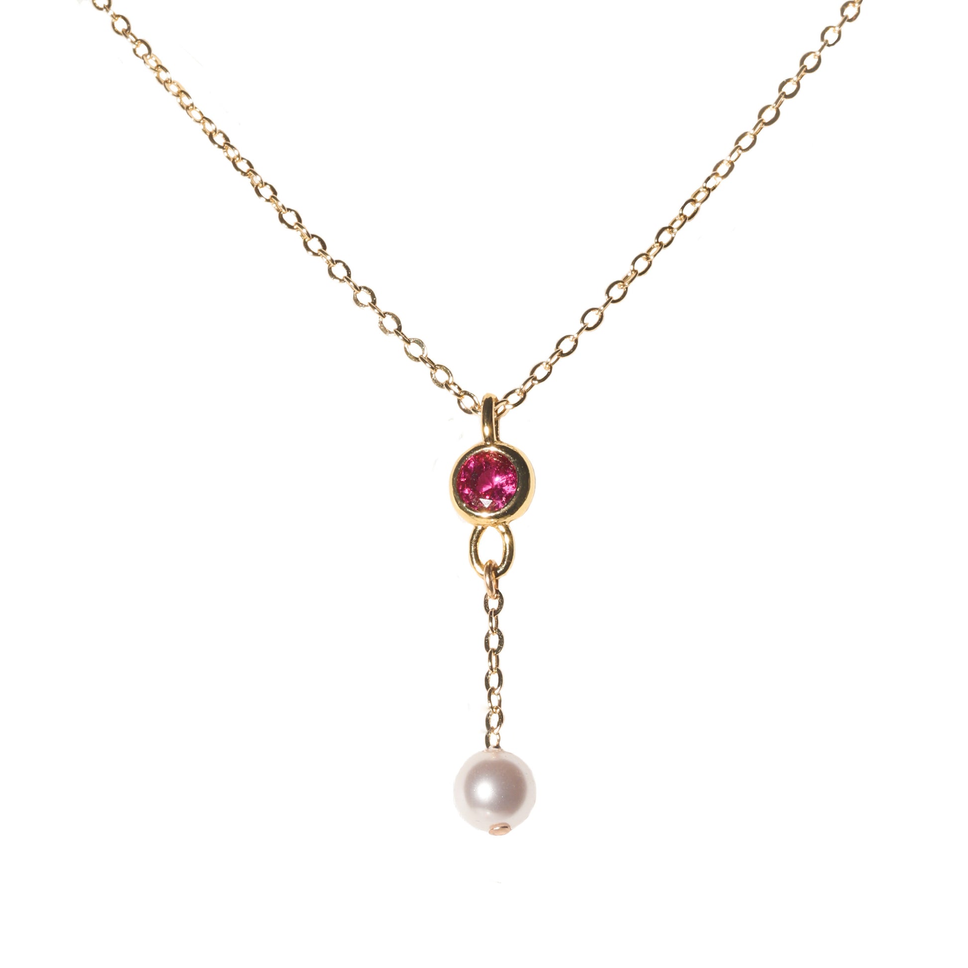 Gold necklace with a pink gemstone and pearl pendant on a white background