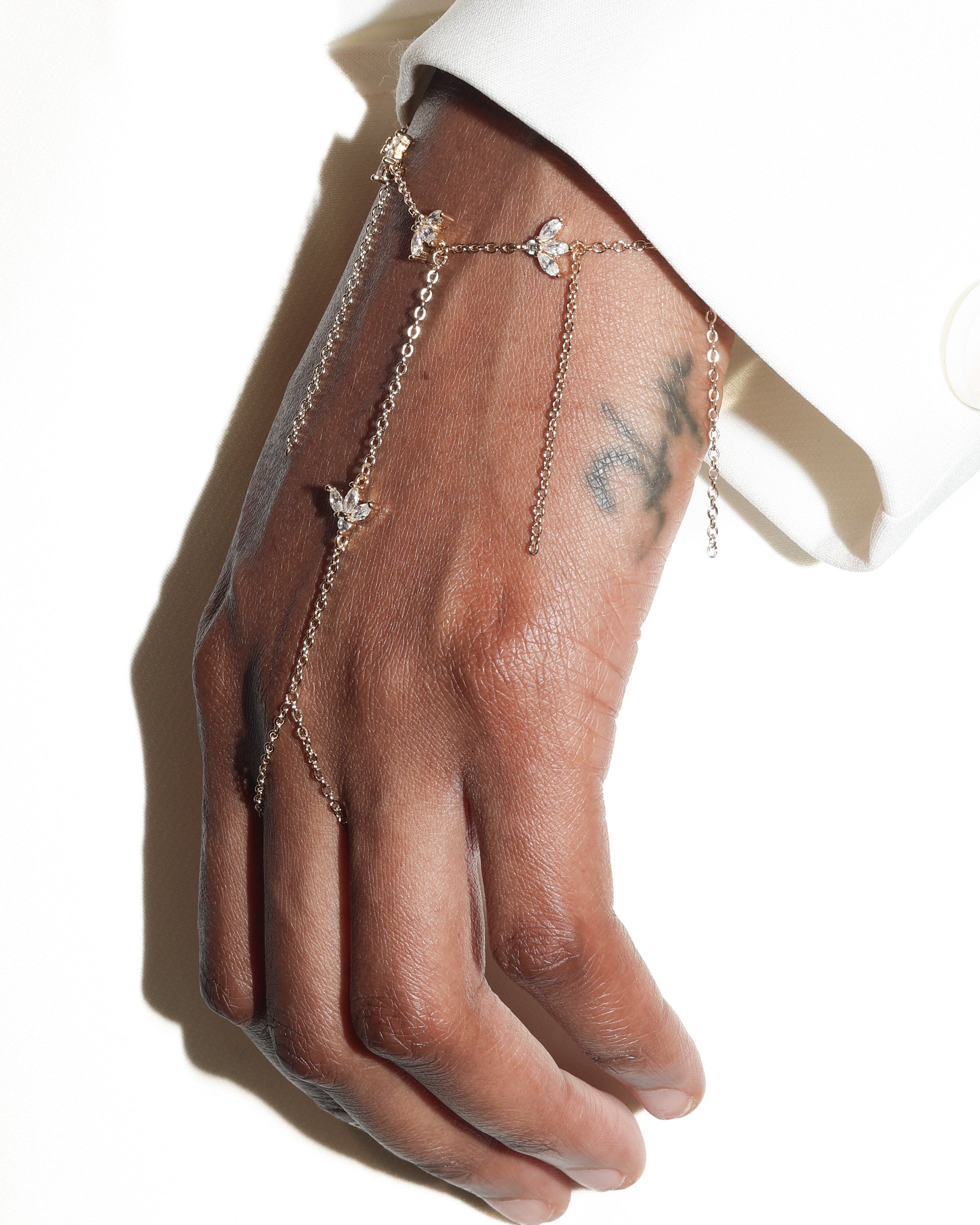 Hand wearing a delicate chain bracelet on a white background