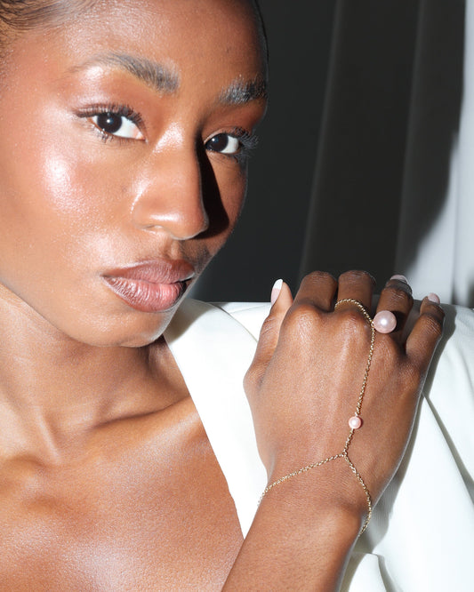 Woman wearing a delicate bracelet on her wrist with a white background