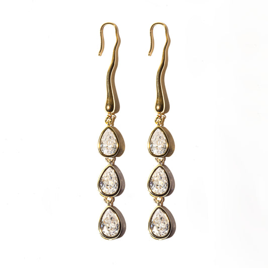 Gold earrings with teardrop-shaped crystals on a white background