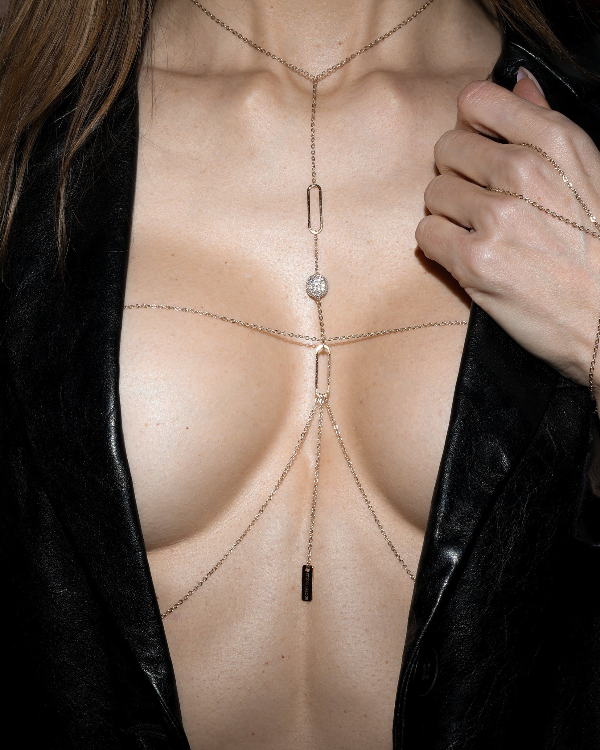 Person wearing a body chain with a black leather jacket